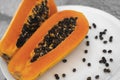 Half cut ripe papaya with seed on a white plate. Slices of sweet papaya with a white background. Halved papayas. Healthy Royalty Free Stock Photo