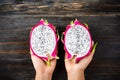 Half dragon fruit holding by hand on wooden Royalty Free Stock Photo