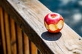 A half-eaten apple on railing outside