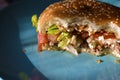 A half-eaten meat Burger with vegetables on a blue plate Royalty Free Stock Photo