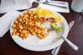 Half-eaten omelette and roasted potatoes on a white plate