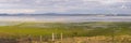 Half empty Lake George between farmland and a wind farm