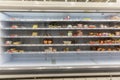 Half empty supermarket shelves with chilled smoked meat delicacies. Popular unhealthy foods. Front view