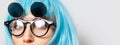 Half face concept; close-up portrait of beautiful eyes of young girl with blue hair wearing round sunglasses on white background. Royalty Free Stock Photo