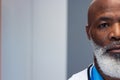 Half face portrait of african american senior male doctor in hospital corridor, copy space Royalty Free Stock Photo