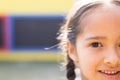 Half face portrait of smiling cauasian elementary schoolgirl in school playground, copy space Royalty Free Stock Photo