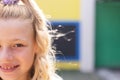 Half face portrait of smiling cauasian elementary schoolgirl in school playground, copy space