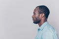 Half-faced side profile view portrait of thoughtful pensive serious confident handsome guy dressed in light blue shirt, isolated