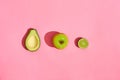 Half Avocado fruits apple on pink background Royalty Free Stock Photo