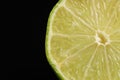 Half of fresh lime on black background, closeup. Space for text Royalty Free Stock Photo