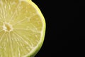 Half of fresh lime on black background, closeup. Space for text Royalty Free Stock Photo