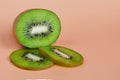 Half fruit and two green slices of kiwi, healthy eating concept on an orange background copy space Royalty Free Stock Photo