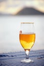 Half full glass of  beer on the table with blurred sea, sky and island background Royalty Free Stock Photo