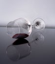 Half-full glass of red wine laying on its reflection on a black and white background Royalty Free Stock Photo