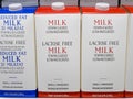 Half gallon cartons of lactose free reduced fat organic milk on fridge shelf.