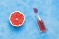 Half a grapefruit and half-full bottle of juice.Abstract blue background, top view. The concept of summer. Royalty Free Stock Photo