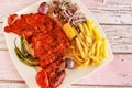 HALF GRILLED TANDOORI CHICKEN with lemon, onion and french fries served in dish isolated wooden table top view of tandoori grill Royalty Free Stock Photo