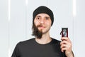 Before - after and half hair. Handsome bearded man trimming his beard with a trimmer Royalty Free Stock Photo