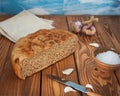 Half homemade bread, young garlic and coarse salt in a clay salt shaker on a wooden brown table Royalty Free Stock Photo