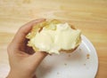 Half of homemade Japanese choux cream puff, seeing plenty of tasty vanilla filling inside.