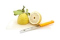 Half Japanese lemon on cutting board with knife, isolated