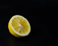 Half of juicy lemon in water droplets