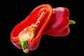 Half and whole red bell pepper on black background Royalty Free Stock Photo