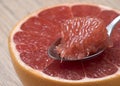 Half of Juicy Ripe Red Grapefruit with slice in a spoon. Royalty Free Stock Photo