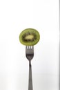 A half of a kiwi pierced on a fork over white background Royalty Free Stock Photo