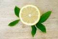 Half a lemon with leaves on a wooden background Royalty Free Stock Photo