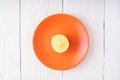 Half of lemon on orange plate