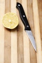 Half of lemon on wood kitchen board and knife Royalty Free Stock Photo