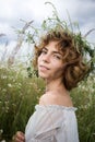 Half-length portrait of a beautiful young woman in white on a field of wild daisies Royalty Free Stock Photo