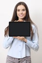 Half-length portrait of brunette young smiling woman showing blank tablet screen to camera isolated on white background Royalty Free Stock Photo