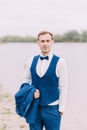 Half-length portrait of the handsome groom spending time on the coast. Royalty Free Stock Photo