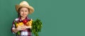 Half-length portrait of little girl, smiling kid in image of farmer, gardener holding vegetables isolated on green