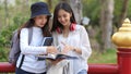 Half-length portrait of two female college students sharing an idea while reading book at the park Royalty Free Stock Photo