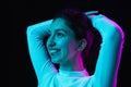 Portrait of young beautiful girl isolated on dark background in neon light Royalty Free Stock Photo