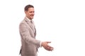 Half length portrait of a young man wearing beige suit , isolated. He welcomes someone to reach out for a handshake. Royalty Free Stock Photo