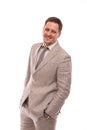 Half length portrait of a young man wearing beige suit , isolated. He is standing with his hands in his pockets and Royalty Free Stock Photo