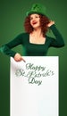 St Patrick Day. Young oktoberfest woman, wearing a dress and green hat with white banner for copy space Royalty Free Stock Photo