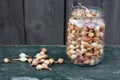 half liter glass jar is filled with small yellow onion seeds. Organic onion heads for planting. Still life with vegetables on