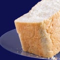 Half loaf of white bread on a plate on a blue background Royalty Free Stock Photo