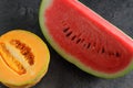 Half melon and a slice of watermelon on dark background Royalty Free Stock Photo