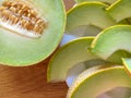 Half melon and melon slice on white plate on wooden table. close Royalty Free Stock Photo