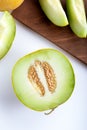 Half melon and sliced pieces of melon on wooden cutting board. Royalty Free Stock Photo