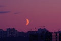 Half moon above city buildings at night Royalty Free Stock Photo