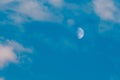 Half moon is seen in daytime, in blue sky with wispy clouds Royalty Free Stock Photo