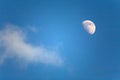 Half moon and a small cloud in the blue sky Royalty Free Stock Photo