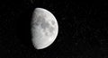 Half moon on a starry dark sky with craters and landform clearly visible Royalty Free Stock Photo